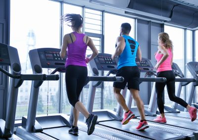 group of young people running on treadmills in modern sport  gym
